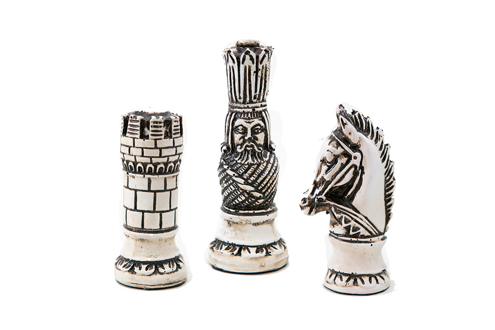 Peças de xadrez de vidro coloridas em tons brilhantes representando cavalos,  cavaleiros e rei em um tabuleiro de xadrez